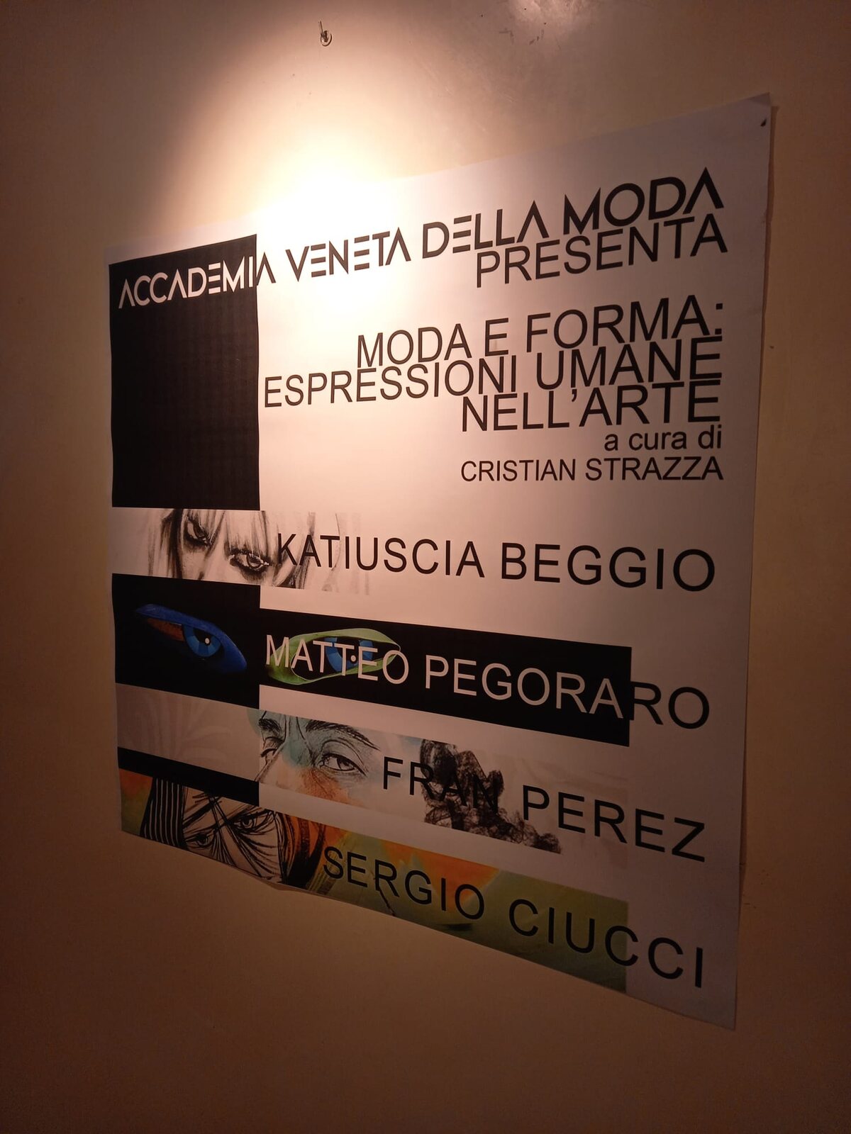 Il manifesto della mostra appeso in sala, con il titolo e i nomi degli artisti.