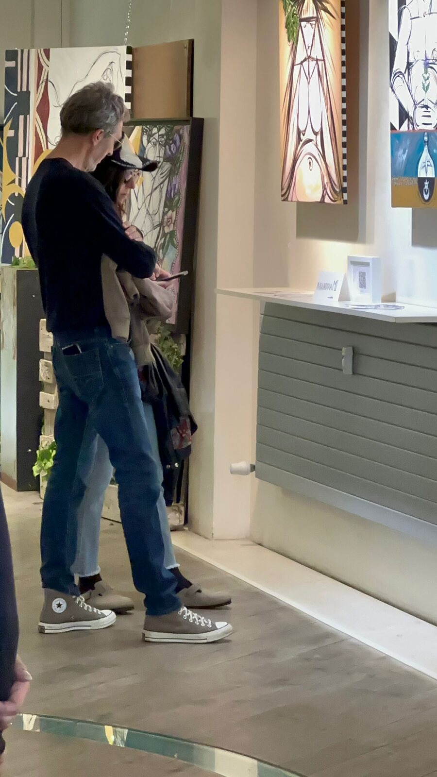 Un visitatore osserva le opere esposte vicino all’ingresso.